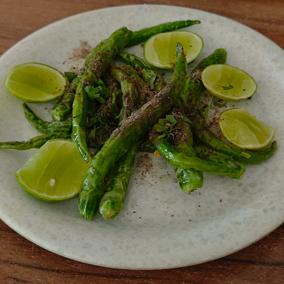 Fried green chillies with lime wedges